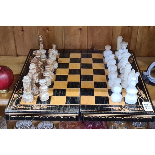 718 - A super complete marble  chess set with pieces in contrasting brown and white hues. Wooden board wit... 