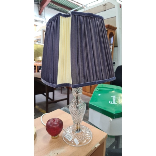 733 - A Large Crystal table lamp with an elegantly pleated fabric shade and a cut glass base.