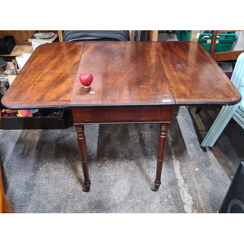 743 - Victorian mahogany drop-leaf table with turned legs and casters. Expandable for additional surface s... 