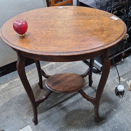 748 - Round oak occasional table with cabriole legs and lower shelf, featuring a warm patina, from the ear... 