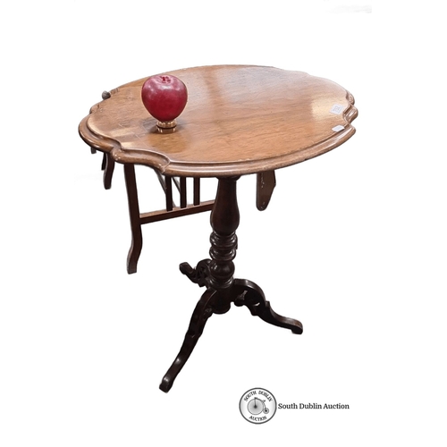 752 - Mahogany pedestal wine table features a scalloped edge top and intricately carved tripod base.