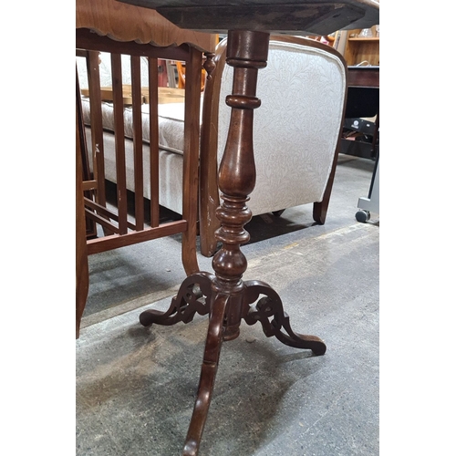 752 - Mahogany pedestal wine table features a scalloped edge top and intricately carved tripod base.