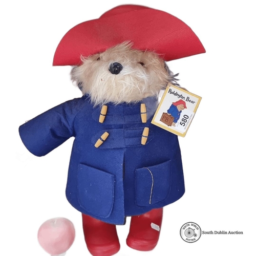 580 - Paddington Bear plush wears a blue coat and red hat, complete with original tags, referencing 