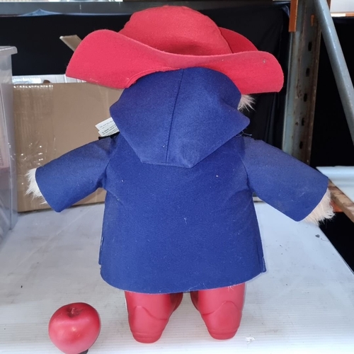 580 - Paddington Bear plush wears a blue coat and red hat, complete with original tags, referencing 