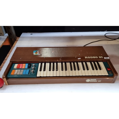 583 - Vintage electronic organ with 37 keys, colored controls, and wood paneling. Supplied by Michael Fole... 