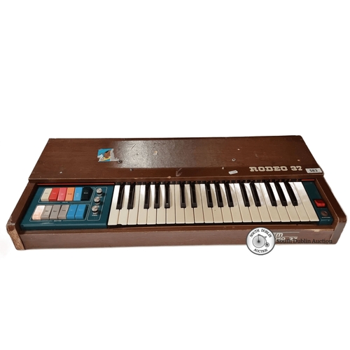 583 - Vintage electronic organ with 37 keys, colored controls, and wood paneling. Supplied by Michael Fole... 