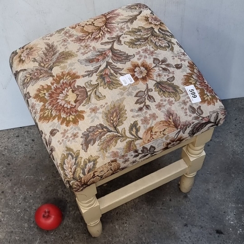 599 - Vintage upholstered stool featuring ornate floral tapestry seat and cream painted wooden legs.