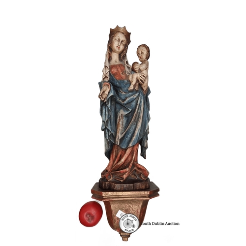 602 - A large wall mounted carved wood Madonna and Child sculpture, displaying rich colors, mounted on a d... 