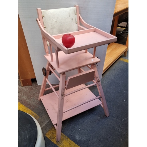 614 - Adjustable pink wooden baby high chair with tray, convertible to a play desk. Features sturdy constr... 