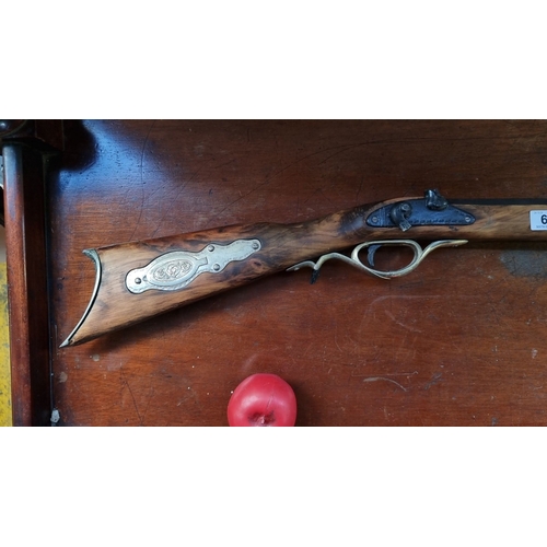 622 - Antique style  flintlock rifle with brass fittings and intricately carved wooden stock, featuring en... 