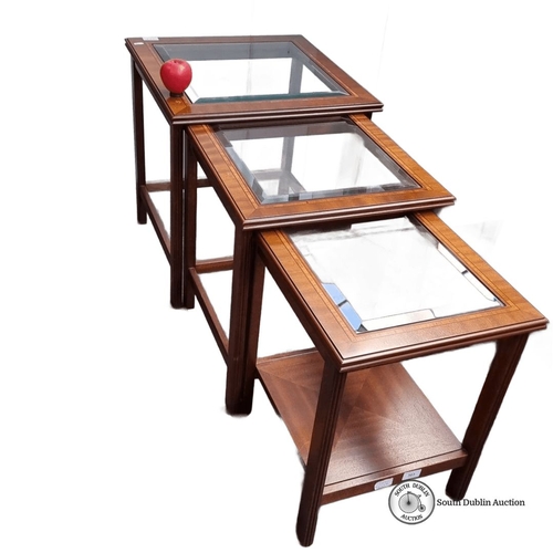 624 - Set of three nesting tables with glass tops and mahogany frames, featuring a classic Mid-Century Mod... 