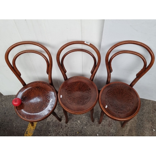 636 - Set of three vintage bentwood chairs with intricately carved seat designs, showcasing classic Thonet... 