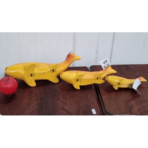 652 - Set of three decorative orange and yellow fish sculptures with mounting brackets, vibrant gradient f... 