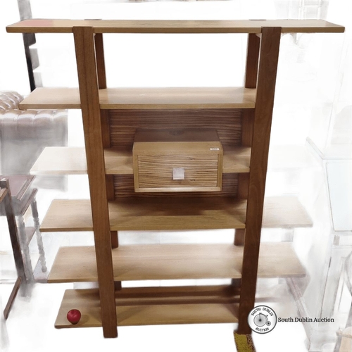 654 - Star lot : A mid century Modern oak shelving unit with six shelves and central drawer. Sleek open de... 