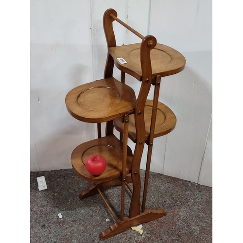 658 - Antique folding cake stand, featuring three tiers with elegantly curved supports, from the early 20t... 