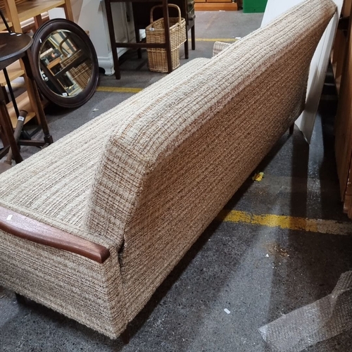 679 - Star Lot : Mid-Century Modern sofa with textured fabric upholstery and wooden armrests, reflecting 1... 