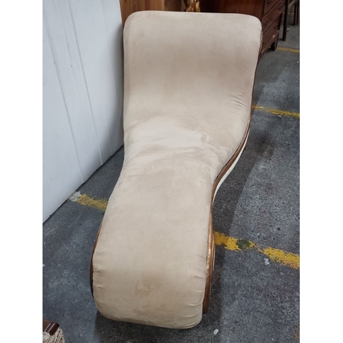 680 - Star Lot : Curved chaise longue with beige upholstery, ornamental gold-toned scroll detailing, and w... 