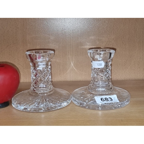 683 - Pair of Waterford crystal candlestick holders featuring elegant cut glass design.