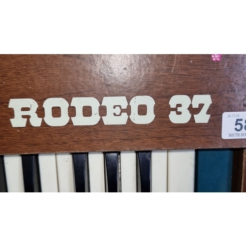 583 - Vintage electronic organ with 37 keys, colored controls, and wood paneling. Supplied by Michael Fole... 