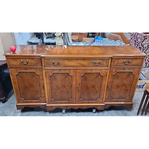 756 - A beautiful satinwood sideboard with four paneled doors and three drawers, featuring elegant hardwar... 