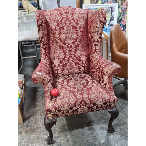 768 - Star Lot : Wingback armchair features ornately carved claw feet and is upholstered in rich red and g... 