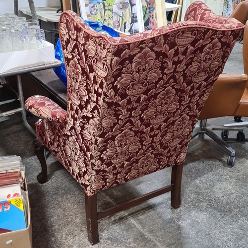 768 - Star Lot : Wingback armchair features ornately carved claw feet and is upholstered in rich red and g... 