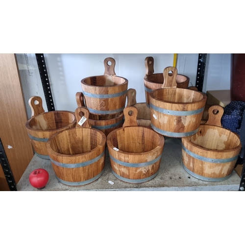 1015 - Set of eight rustic oak buckets with metal bands, featuring cut-out handles.