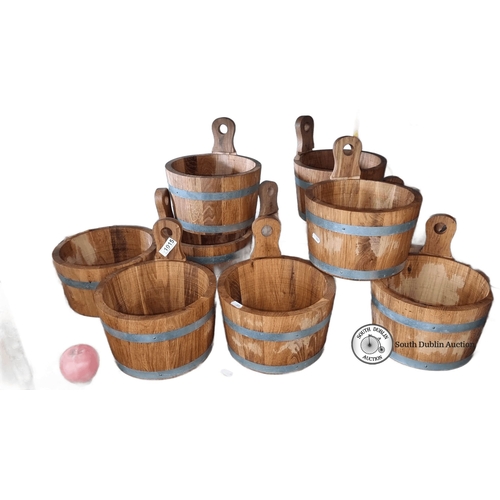 1015 - Set of eight rustic oak buckets with metal bands, featuring cut-out handles.