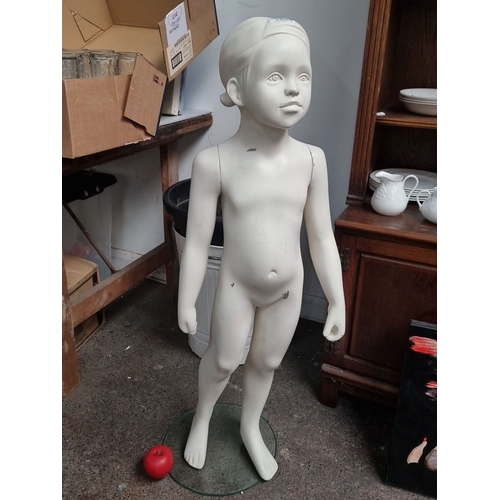 1024 - Child mannequin with a painted finish, mounted on a round glass base.