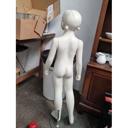 1024 - Child mannequin with a painted finish, mounted on a round glass base.