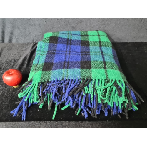 904 - A warm 100 % wool plaid blanket. Features shades of deep greens and blues.