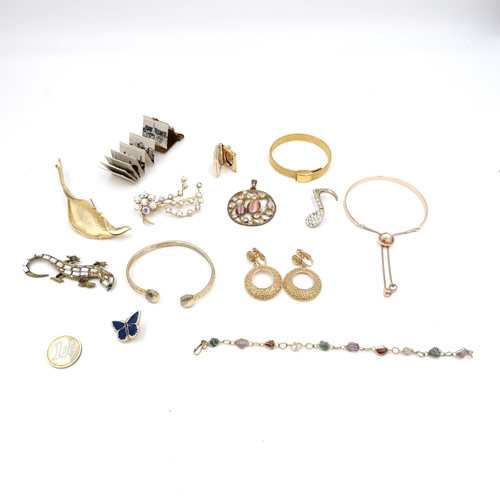 1058 - A good bag of gold toned jewellery Including a long mirrored reptile brooch, A miniature book, a loc... 