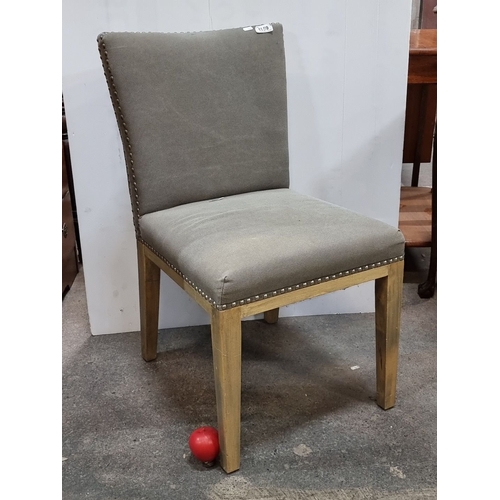 1134 - Upholstered dining chair with wooden legs, featuring nailhead trim. Approximately 32 inches high, 20... 