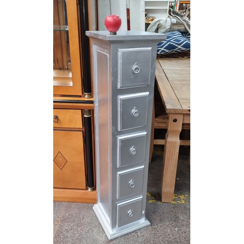 1157 - Silver-finished narrow chest of drawers, featuring five drawers with ring handles and a decorative a... 