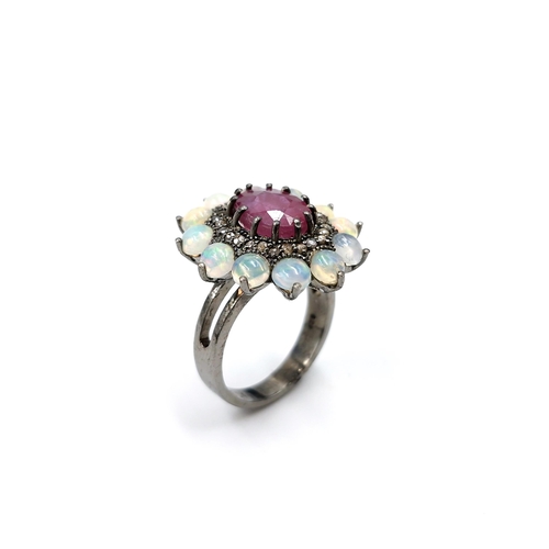 561 - Star Lot : A very attractive 3.7ct ruby set ring with .20ct diamond and 2.90cts opal surround mounte... 