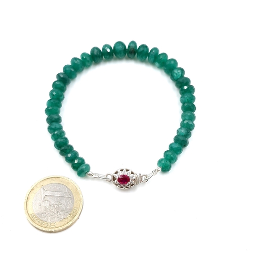 562 - A vibrant graduated natural emerald gemstone bracelet of 80cts set with ruby tongue clasp. Weight: 1... 