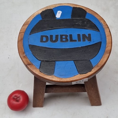 607 - Wooden stool featuring a painted Dublin motif. Compact, rustic design with sturdy legs.