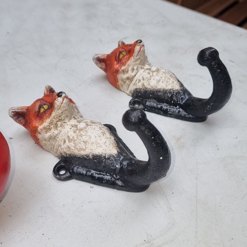 613 - Pair of vintage cast iron heavy fox head wall hooks, featuring hand-painted detail.