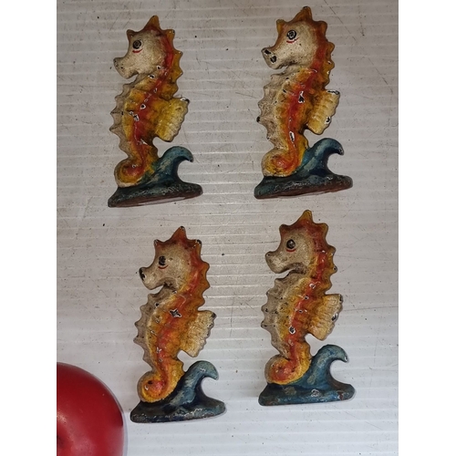 634 - Set of four vintage seahorse cast iron figures with colorful painted finish, featuring orange and bl... 