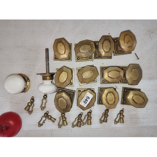 640 - Set of vintage brass and ceramic door knobs with matching keyhole escutcheons. Includes 12 brass kno... 