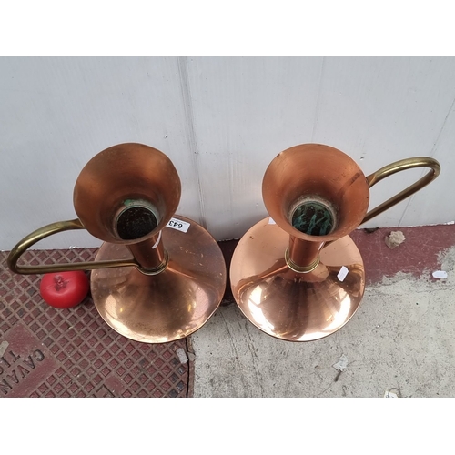 643 - Pair of vintage copper ewers with brass handles, featuring sleek, elongated necks with a flared open... 