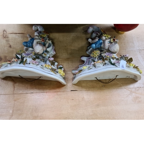 690 - Pair of porcelain wall sconces featuring cherubs and floral motifs, hand-painted in vibrant colors. ... 