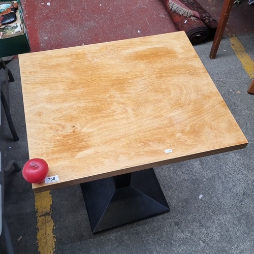 758 - Square commercial  table with light wood top and sturdy black pedestal base.