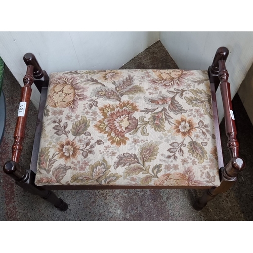 784 - Upholstered storage footstool, with turned wooden legs and floral tapestry fabric. Hinged lid reveal... 