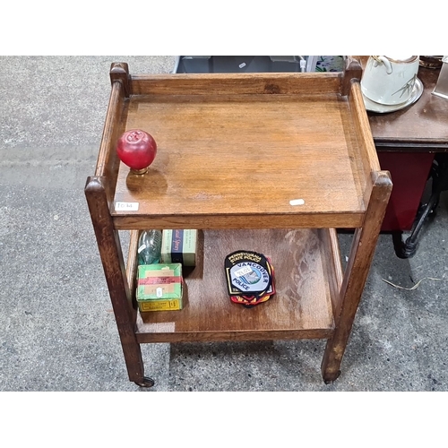 1074 - Antique wooden serving trolley, two-tiered with castor wheels, featuring natural oak finish.