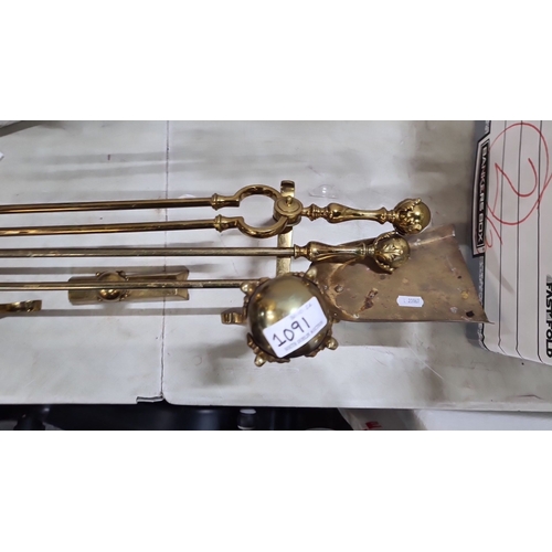 1091 - A victorian Brass fireplace tool set with ornate handles includes three tools and fire dogs.