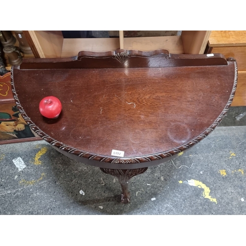 1252 - Mahogany demi-lune table with carved detailing, cabriole legs, and claw feet. From the early 20th ce... 