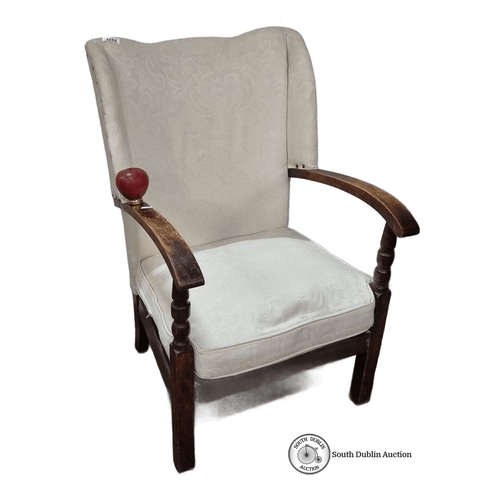 1253 - Upholstered armchair with carved wooden arms and legs, featuring a classic wingback design with crea... 