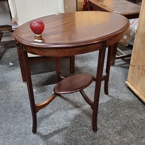 1261 - Oval mahogany side table, from the early 20th century, features delicate inlay detail and a lower sh... 