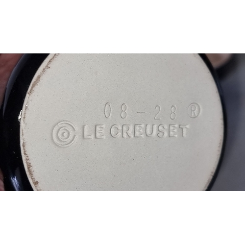 1297 - Pair of as new Le Creuset black stoneware mini cocottes, embossed logo, marked 08-28R.